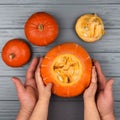 Hands of a daughter and father who pulls seeds and fibrous material from a pumpkin before carving for Halloween. Party Royalty Free Stock Photo