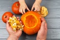 Hands of a daughter and father who pulls seeds and fibrous material from a pumpkin before carving for Halloween. Party Royalty Free Stock Photo