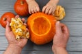 Hands of a daughter and father who pulls seeds and fibrous material from a pumpkin before carving for Halloween. Party Royalty Free Stock Photo