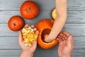 Hands of a daughter and father who pulls seeds and fibrous material from a pumpkin before carving for Halloween. Party Royalty Free Stock Photo