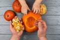 Hands of a daughter and father who pulls seeds and fibrous material from a pumpkin before carving for Halloween. Party Royalty Free Stock Photo