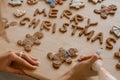 Hands decorating gingerbread cookie. Top view on many cookies and letters marry christmas from food