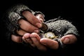 Hands in dirty and torn gloves of a young poor man holding a few cents, close-up. A homeless man counts euros to buy himself a hot