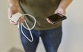 Hands displaying smartphone and USB power adapter with cable before charging Royalty Free Stock Photo