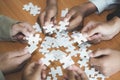 Hands of diverse people assembling jigsaw puzzle, team put pieces together searching for right match, help support in teamwork to Royalty Free Stock Photo