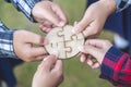 Hands of diverse people assembling jigsaw puzzle, team put pieces together searching for right match, help support in teamwork to Royalty Free Stock Photo