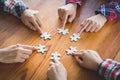 Hands of diverse people assembling jigsaw puzzle, Youth team put