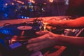 Hands of a DJ putting a vinyl record on a record player in a music club in the rays of blue and red light Royalty Free Stock Photo