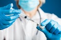 Hands of a doctor in medical gloves draws a liquid vaccine against the corona virus covid 19 into a syringe from a vial preparing Royalty Free Stock Photo