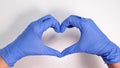 Hands of a doctor or nurse in medical gloves depict a heart on a white background, caring doctor and medicine concept Royalty Free Stock Photo