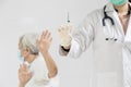 Hands of doctor preparing a syringe to inject the elderly,old people showing distrustful of COVID-19 vaccine,rejecting medicine, Royalty Free Stock Photo