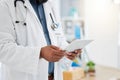 Hands of a doctor using a digital tablet. Closeup of african american doctor using wireless device in hospital office