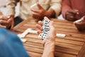 Hands, dominoes and friends in board games on wooden table for fun activity, social bonding or gathering. Hand of domino Royalty Free Stock Photo