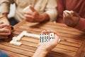 Hands, dominoes and friends in board games on wooden table for fun activity, social bonding or gathering. Hand of domino Royalty Free Stock Photo