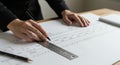 Person Drawing Technical Plan with Ruler and Pen on White Paper Royalty Free Stock Photo