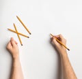 Hands drawing writing on a white background with a crayon