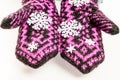 Hands dressed in mittens handmade hold snowflakes