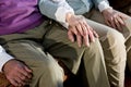 Hands of elderly couple touching on knee