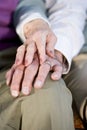 Hands of elderly couple touching on knee