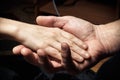 Hands of an elderly man holding the hand of a younger man. Royalty Free Stock Photo