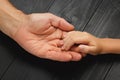 Hands of elderly man holding hand of younger man. Royalty Free Stock Photo