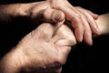 Hands of an elderly man holding the hand of a younger man. Royalty Free Stock Photo