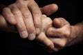 Hands of an elderly man holding the hand of a younger man. Royalty Free Stock Photo