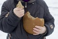 Hands of an elderly woman breaking off a piece of bread