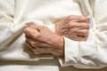 Hands of elderly woman clenched in fists on her chest