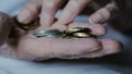 The hands of an elderly woman consider a trifle. The poor pensioner counts the last money. Coins in the hand of an old Royalty Free Stock Photo