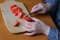 Hands of an elderly woman cutting a red ripe tomato Royalty Free Stock Photo