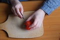 Hands of an elderly woman cutting a red ripe tomato Royalty Free Stock Photo