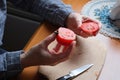 Hands of an elderly woman cutting a red ripe tomato Royalty Free Stock Photo