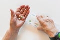 Hands of elderly woman holding pills and medicine, white background Royalty Free Stock Photo