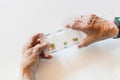 Hands of elderly woman holding pills and medicine, white background Royalty Free Stock Photo