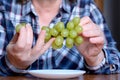 The hands of an elderly woman holds a small brush of white seedless grapes Royalty Free Stock Photo