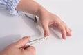 Hands of an elderly woman in wrinkles close-up, clippers, scissors, cutting nails, care, manicure at home, concept of beauty and Royalty Free Stock Photo