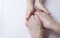 Hands of an elderly woman in the hands of a young woman caring for old age Royalty Free Stock Photo