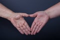 Hands of elderly and young women on black background Royalty Free Stock Photo