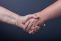 Hands of elderly and young women on black background Royalty Free Stock Photo