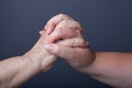 Hands of elderly and young women on black background Royalty Free Stock Photo