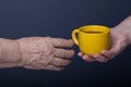 Hands of elderly and young women on black background Royalty Free Stock Photo