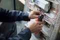 Hands of electrician assembling industrial HVAC control cubicle in workshop. Close-up photo.