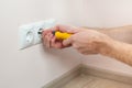 The hands of an electrician installing a wall power socket. Royalty Free Stock Photo