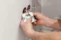 The hands of an electrician installing a wall power socket. Royalty Free Stock Photo