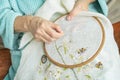 Hands embroidery, woman hands with fabric and wooden embroidery hoop Royalty Free Stock Photo