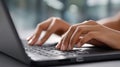 Hands are engaged in typing on a laptop keyboard at a desk in an office environment, focusing on work or study tasks Royalty Free Stock Photo