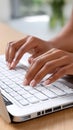 Hands are engaged in typing on a laptop keyboard at a desk in an office environment, focusing on work or study tasks Royalty Free Stock Photo