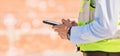 Hands of engineer on construction site, typing on phone and checking email for building schedule with mockup Royalty Free Stock Photo