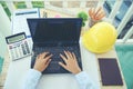 Hands of Engineer using laptop wear yellow helmet for safety. Construction Concept Royalty Free Stock Photo